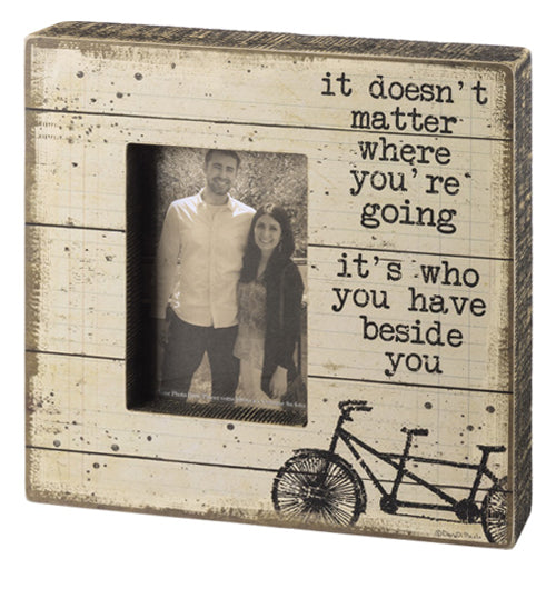 An off-white wooden box sign with the phrase "It doesn&