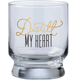 A bar glass with the words "Distilled drinker" on it in black and gold text.
