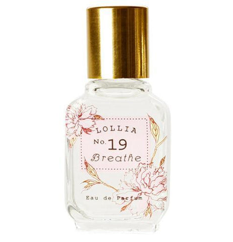 Perfume is in a white bottle with a gold top and pink flowers.
