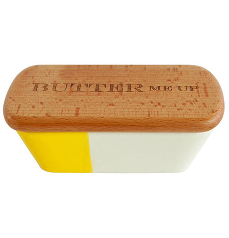 A butter tub 1/3 is yellow and rest is white with a wooden lid that says "Butter me up".