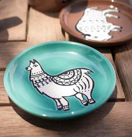 Round "Teal Llama" coaster with white llama design on a natural wood table next to "Brown Buffalo" coaster with white buffalo design.