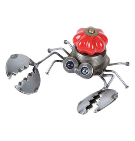 This is a metal sculpture of a crab with a red doorknob in its middle to make up its shell. The crab's metal pincers are extended and open as though ready to pinch.