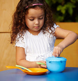 little girl playing with the blue pot and skillet with the yellow spatula