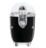 This black juicer shows the view of the juicer spout, the top is clear and shows the citrus grinder and the bowl. on the middle left side shows a G and the right shows an S,