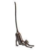 Cast-iron cat paper towel holder that looks like a cat with a long tail stretched out on a white background.