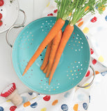 Metal Turquoise Colander with Handles and a Display of Carrots