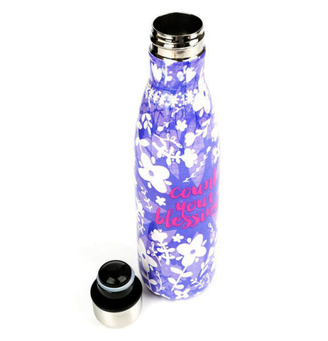 Water bottle with a purple background and flowers in the foreground and in the center it says "Count Your Blessings" with its cap off and sitting next to it.