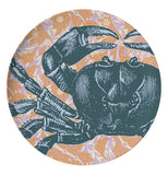 This plate has a design of a dark blue crab against an orange oceanic background.