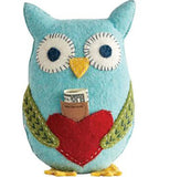A blue felt owl has green wings, yellow feet and red heart in the middle. A piece of paper with the words "tooth fairy pillow" and a dollar bill stick out.