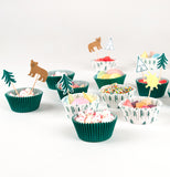 Eleven of the "Let's Explore" cupcakes six are green and five are white with green pine trees filled with candy and decorated with bears, trees, sun, and teepees toppers. 