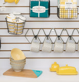 This display features different kitchen items such as cups,bowls,butter dish. different colored dishtowels in their packaging.