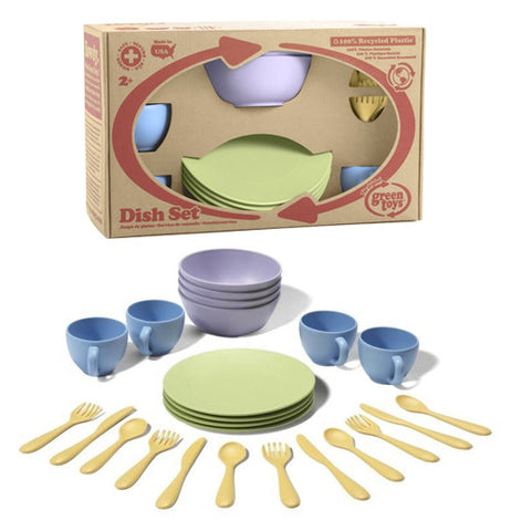This child's play set includes four green plates, four blue cups, four purple bowls and fours sets of knives, spoons and forks displayed in front of the set in its original packaging.