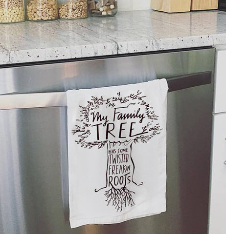 Family tree dish towel hanging on the oven door.