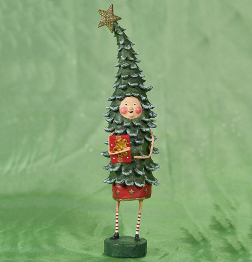 A kid in a Christmas tree costume is holding a red present. The tree costume has a yellow, sparkly star on top. The kid wears red and white striped socks. The background is green.