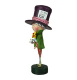 This is the side of the Mad Hatter figurine wearing red pants with white stripes, blue vest with a green coat, a yellow bow tie with red dots and an oversized top hat with a card in the hatband that reads "In This Style 10/6" .