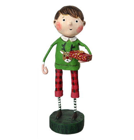 This figurine is of a boy dressed in red pants with black spots, and a green sweater with a reindeer's head. The boy holds a present wrapped in red paper in his right hand.