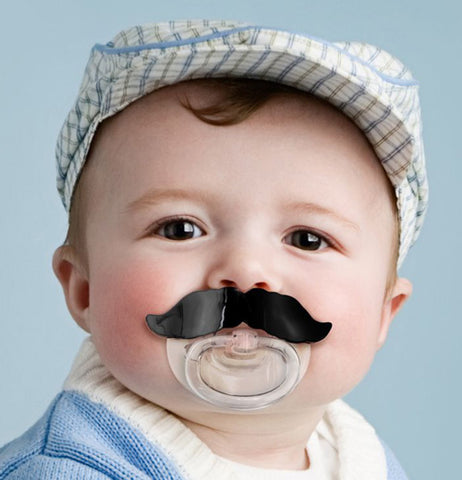 A sweet baby sucking on a Chill Baby "Mustache" Pacifier. 