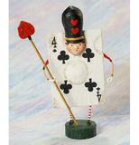 The four of clubs card figurine is shown in front of a rainbow painted wall.