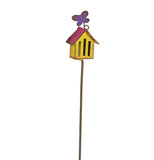 The Butterfly House has a purple butterfly on top of a yellow house with a red roof on a metal pole. 