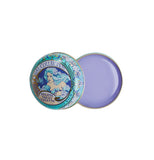 A circular blue and white art neaveau tin has purple lip balm in it.