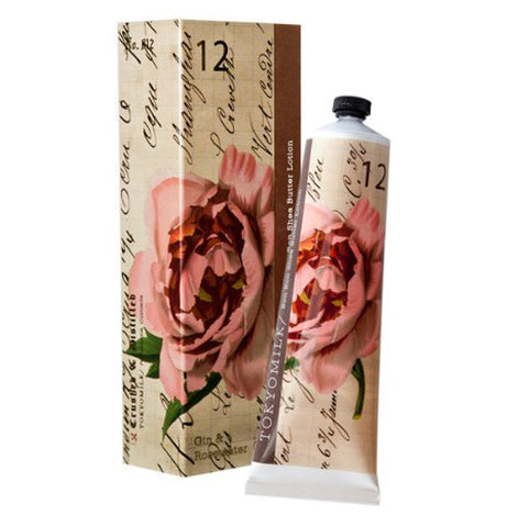 This Shea butter lotion with a soft on the eye flower on the tube and box. The tube is placed next to the box.