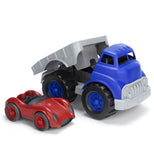 blue and grey flatbed truck with the bed tilted back with a red racing car next to it
