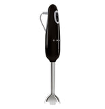  The side view of this black colored hand blender shows the on/off button and the half logo of SMEG and on the left he grey power cable, the base part is silver.