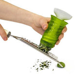 The Herb Keeper is grating some herbs on a metal cheese grater.
