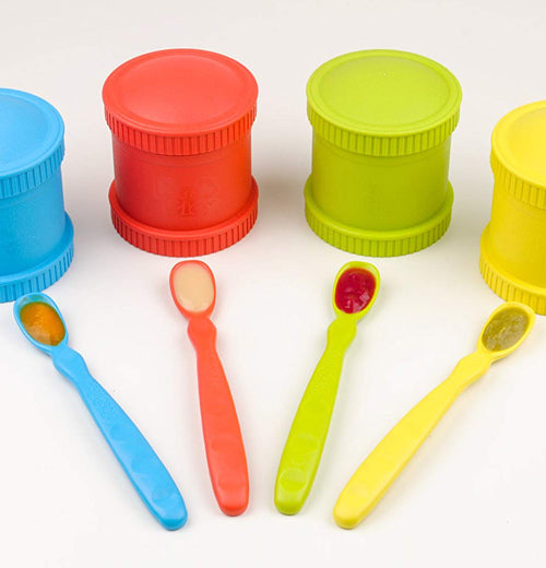 The Four "Primary" Infant Spoons lay on the table with the Four canisters with the same color as the spoons. 