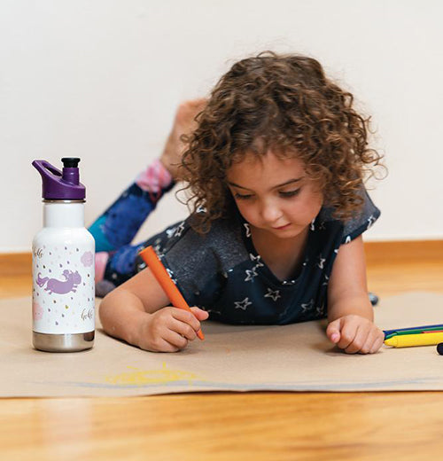 A Girl drawing with her insulated water bottle with with pink and purple dogs on it.