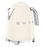 A cream tea kettle has a silver handle with a silver spout, the base is also silver and the logo "Smeg" on its side