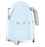 A pastel blue tea kettle has a silver handle with a silver spout, the base is also silver and the logo "Smeg" on its side
