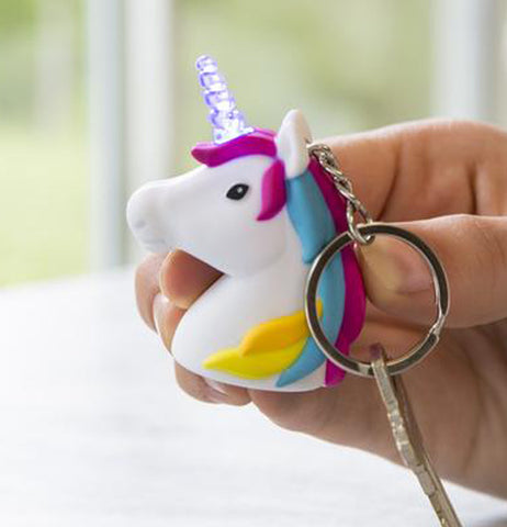 This image shows a  hand holding the "Unicorn" Keychain with a key in the holder. 
