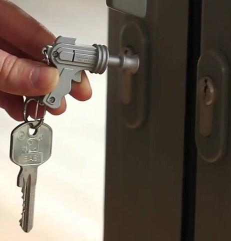 A person's hand is shown holding the led space gun-shaped key ring.