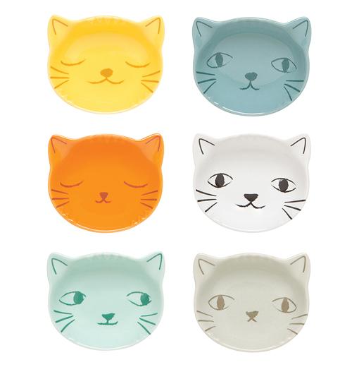 These small bowls are all shaped like cats' faces. One is yellow, the others orange, blue, turquoise, gray, and darker gray.
