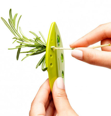Two hands use a LooseLleaf kale and greens stripper to strip rosemary from the stem.