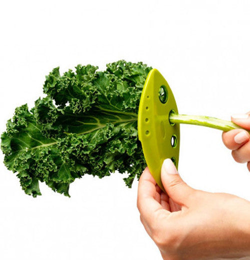 Two hands use a LooseLleaf kale and greens stripper to strip kale from the stem.