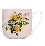 Pink ceramic mug has yellow roses and green leaves and says" Make it Strong."