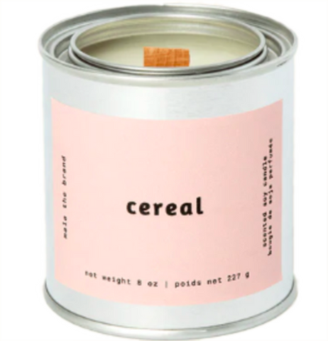 A gray tin candle-shaped can with a pastel pink label. The label says "Mala the brand--cereal--Net weight 8 oz. -- scented soy candle." There is also French text, but this alt text writer is woefully monolingual.