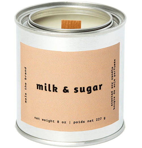 A gray tin candle-shaped can with a pastel brown label. The label says "Mala the brand--milk &amp; sugar--Net weight 8 oz. -- scented soy candle." There is also French text, but this alt text writer is woefully monolingual.