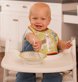 A baby using his "Mama Llama" silverware to eat.