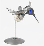 The metal hummingbird sculpture is shown from the opposite side angle.