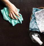 A woman's hand is shown cleaning a stove with one of the bunny design cloths.