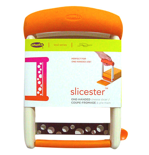 The cheese slicer wrapped in its plastic selling cover