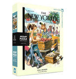 A box containing a 1000 piece jigsaw puzzle is shown with a picture of a woman with a baby in a carriage buying apples from a street merchant. The words, "The New Yorker" are shown above the image in black lettering.