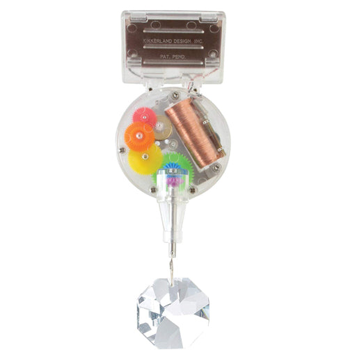 The Solar Powered Rainbow Maker is made of transparent plastic to show the mechanical inner working gears and has an octagonal prism hanging from the bottom.