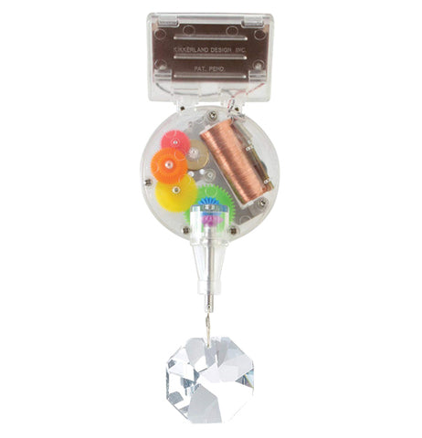 The Solar Powered Rainbow Maker is made of transparent plastic to show the mechanical inner working gears and has an octagonal prism hanging from the bottom.