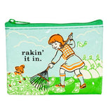 Coin purse with with a green zipper and an image of a girl raking money that her dog is playing in with white bags of cash in the background. It has the words Rakin' it in printed in black over the background of a light blue sky with clouds.