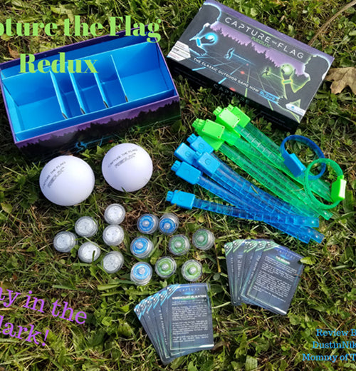 The equipment for the glow-in-the-dark capture-the-flag game is shown lying on grass during the day.