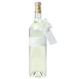 Foaming bath is in a large clear bottle with a white flower and a cork top.